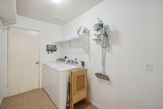 washroom with washing machine and dryer and light tile patterned floors