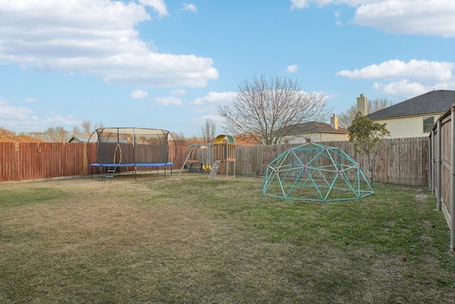 view of yard with a playground and a trampoline