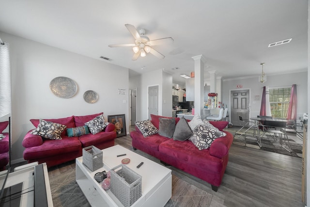 living room with dark hardwood / wood-style flooring, decorative columns, and ceiling fan