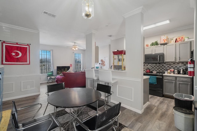 dining space with crown molding, ceiling fan, and hardwood / wood-style floors