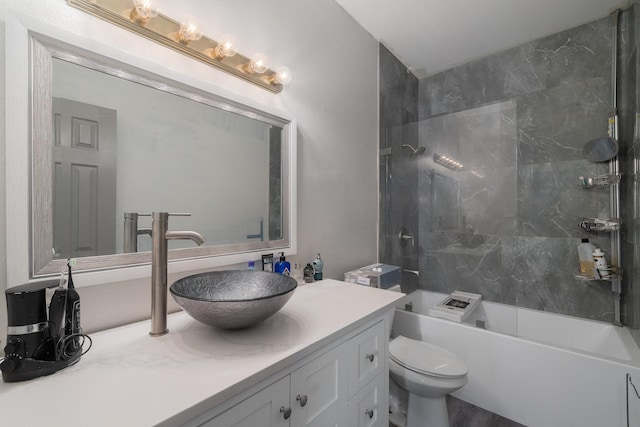 full bathroom with tiled shower / bath, vanity, and toilet