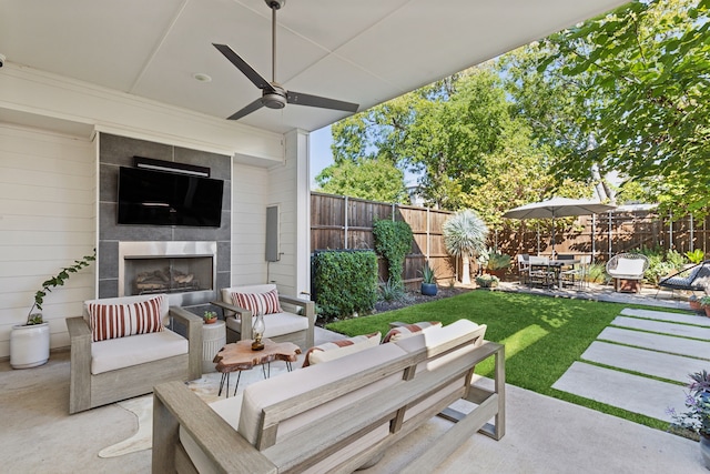 view of patio with an outdoor living space with a fireplace and ceiling fan