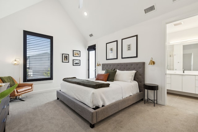 carpeted bedroom with sink, high vaulted ceiling, and ensuite bathroom