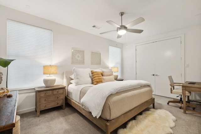 carpeted bedroom with ceiling fan and a closet