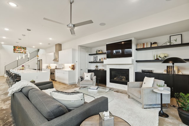 living room with a premium fireplace and ceiling fan