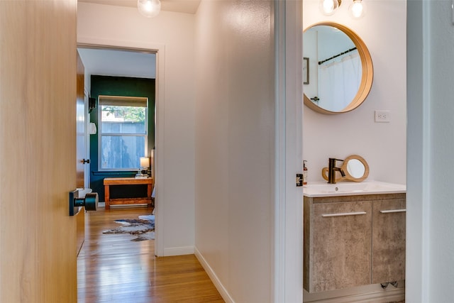 hallway with sink and light hardwood / wood-style flooring