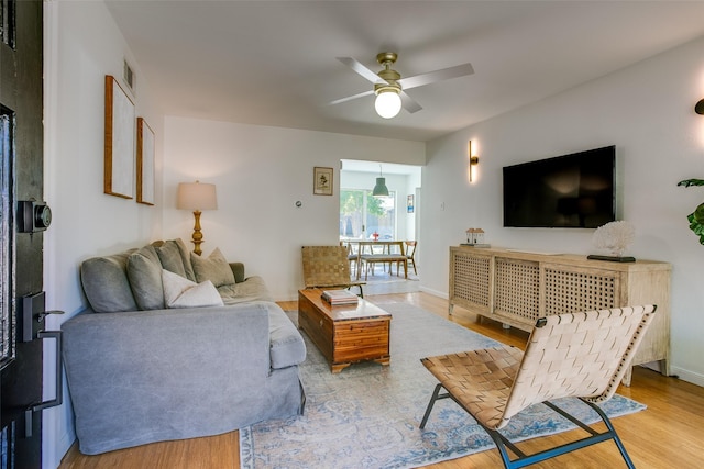 living room featuring ceiling fan and light hardwood / wood-style floors