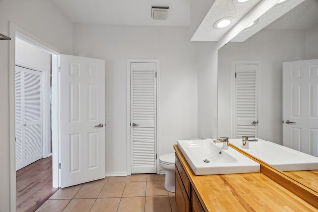 bathroom featuring vanity, tile patterned floors, and toilet