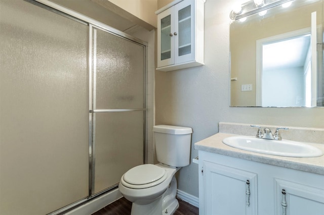 bathroom featuring vanity, toilet, and a shower with shower door