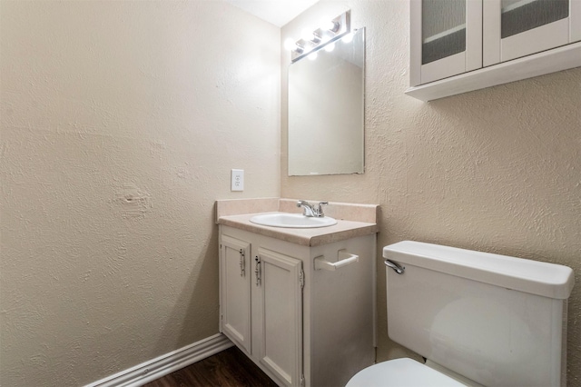 bathroom featuring vanity, wood-type flooring, and toilet