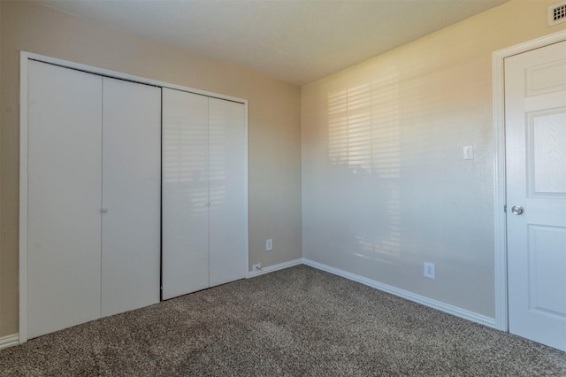 unfurnished bedroom with a closet and carpet flooring