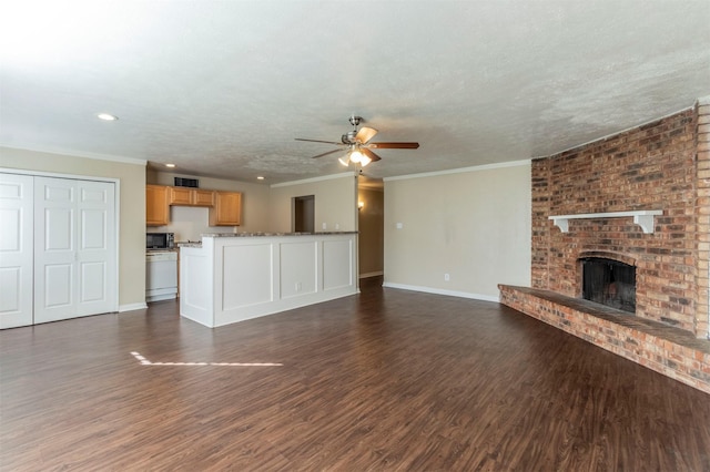 unfurnished living room featuring a brick fireplace, a textured ceiling, ornamental molding, dark hardwood / wood-style flooring, and ceiling fan