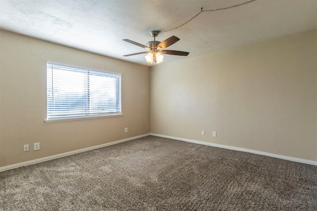 unfurnished room with ceiling fan and carpet