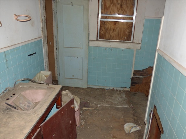 bathroom with tile walls and toilet