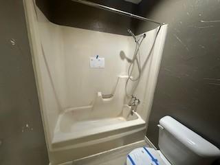 bathroom with toilet and  shower combination