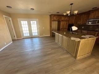 kitchen with hanging light fixtures, a center island, a chandelier, and hardwood / wood-style flooring