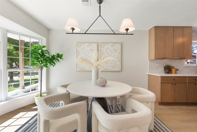 dining space with a healthy amount of sunlight and light hardwood / wood-style floors