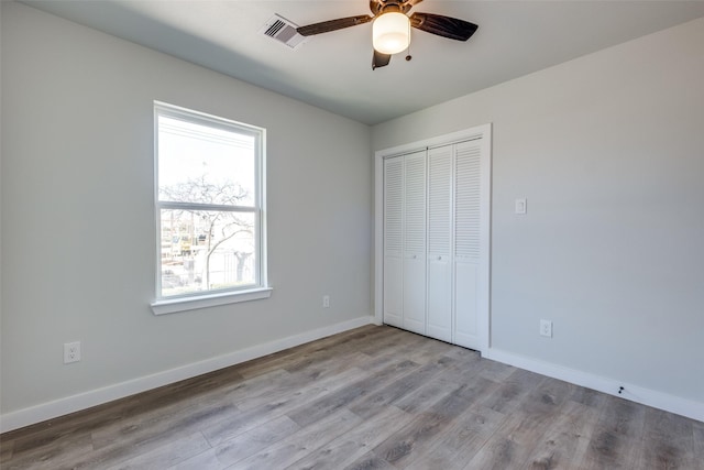 unfurnished bedroom with ceiling fan, a closet, and light wood-type flooring