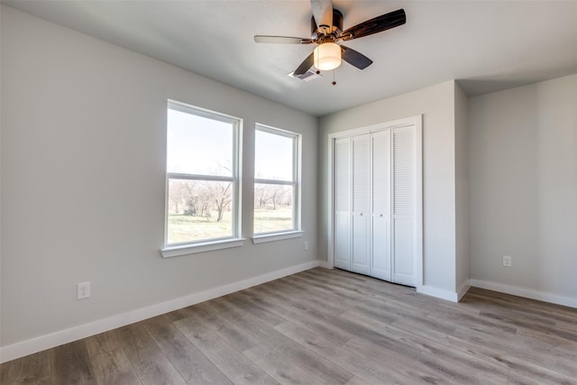 unfurnished bedroom with ceiling fan, a closet, and light hardwood / wood-style flooring