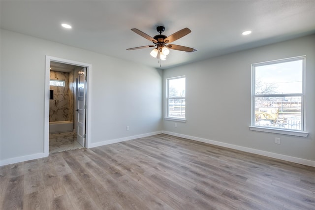 empty room with ceiling fan and light hardwood / wood-style floors