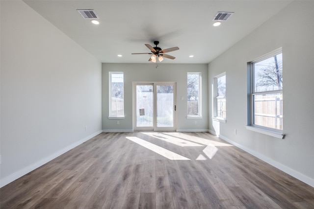 empty room with ceiling fan and light hardwood / wood-style flooring