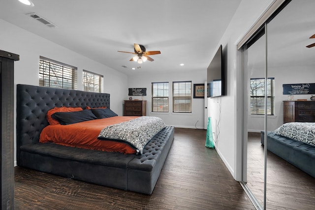 bedroom featuring a closet, dark hardwood / wood-style floors, and ceiling fan