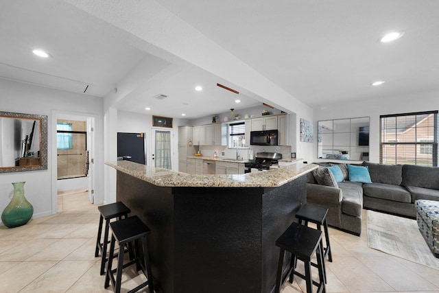 kitchen with black appliances, a kitchen breakfast bar, kitchen peninsula, and light tile patterned floors