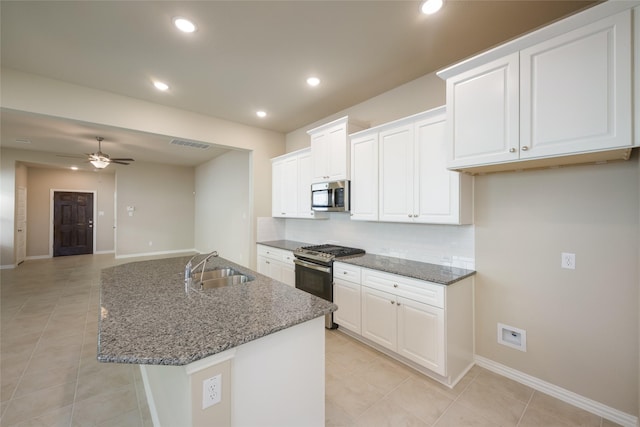 kitchen featuring a center island with sink, sink, ceiling fan, appliances with stainless steel finishes, and white cabinetry