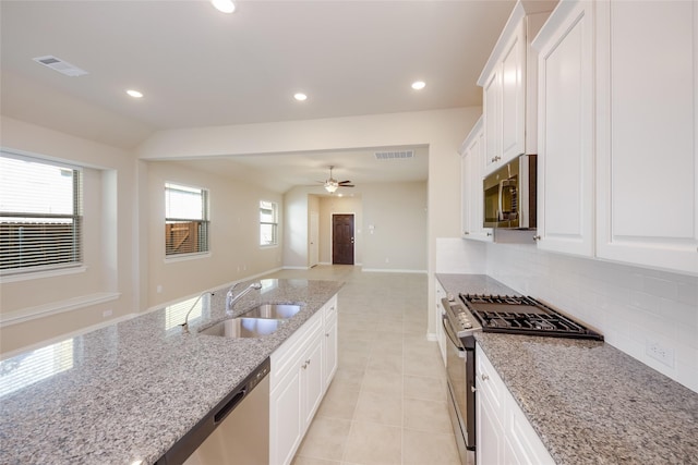 kitchen with white cabinetry, appliances with stainless steel finishes, sink, and light stone counters