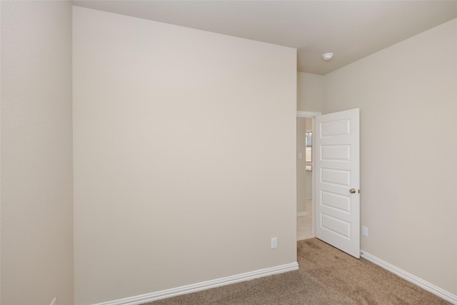 unfurnished room featuring light carpet