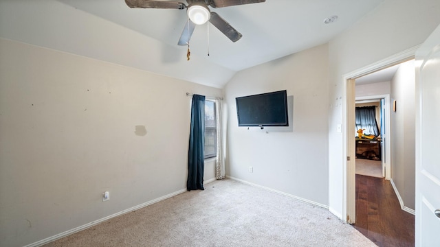 unfurnished bedroom featuring light carpet, vaulted ceiling, and ceiling fan