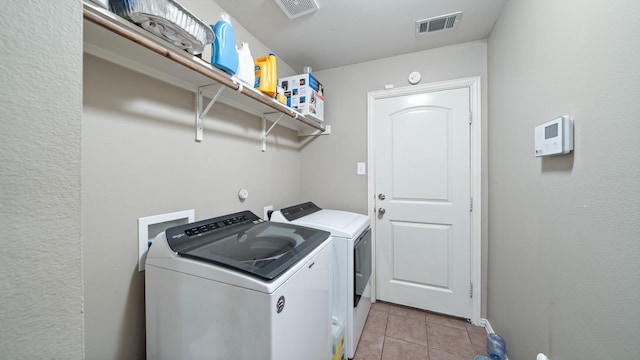 washroom featuring washer and clothes dryer and light tile patterned flooring