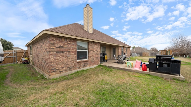 back of house with a lawn and a patio