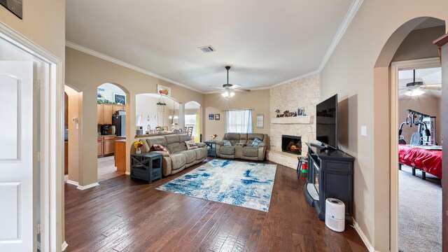 living room featuring a fireplace, dark hardwood / wood-style floors, ceiling fan, and ornamental molding