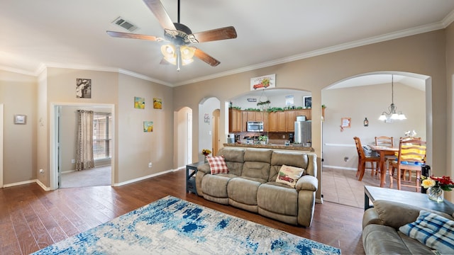 living room with lofted ceiling, dark hardwood / wood-style flooring, ceiling fan with notable chandelier, and ornamental molding