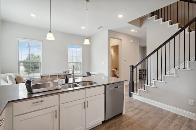 kitchen with white cabinets, stainless steel dishwasher, hanging light fixtures, and sink