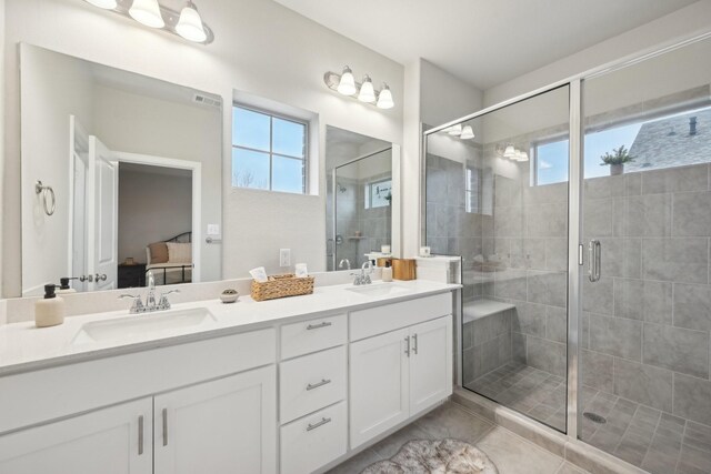 bathroom featuring tile patterned floors, a shower with door, and vanity