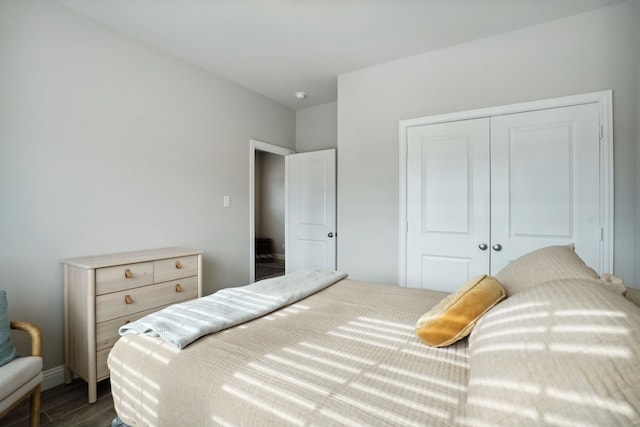 bedroom with dark hardwood / wood-style flooring and a closet