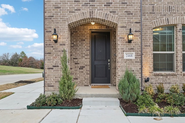 doorway to property with brick siding