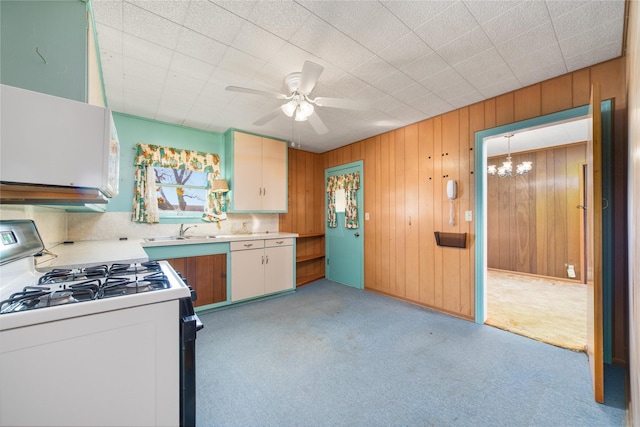 kitchen featuring light carpet, ceiling fan with notable chandelier, sink, white cabinetry, and white range with gas cooktop