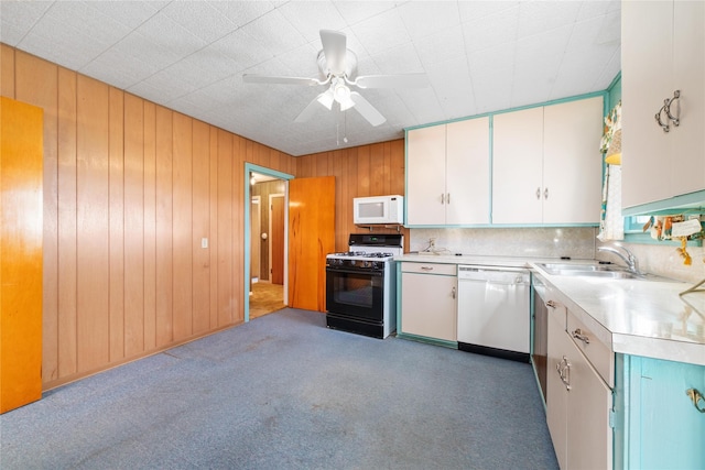 kitchen with sink, white cabinets, white appliances, and dark colored carpet