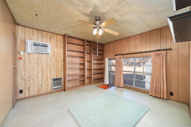 empty room with a wall unit AC, built in shelves, wooden walls, and ceiling fan