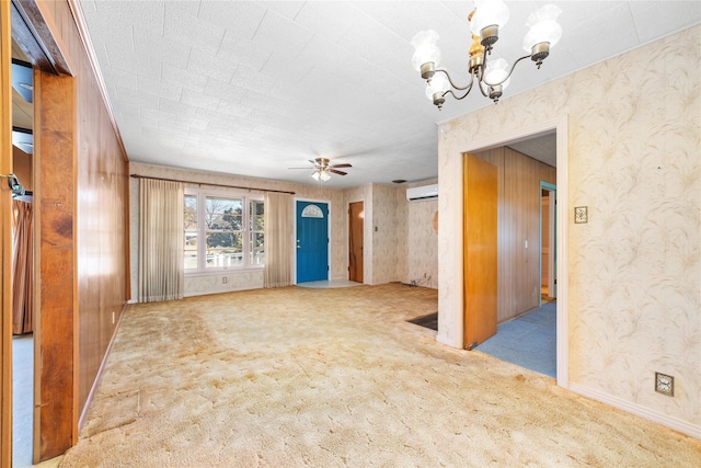 interior space with ceiling fan with notable chandelier and an AC wall unit