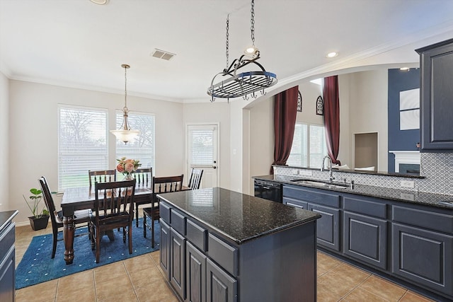 kitchen featuring visible vents, arched walkways, a sink, crown molding, and backsplash