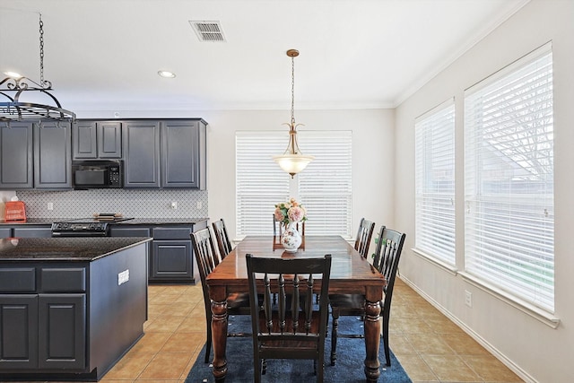 dining area featuring visible vents, baseboards, light tile patterned flooring, and crown molding