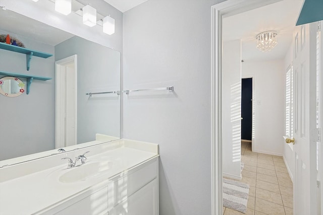 bathroom featuring baseboards, a notable chandelier, vanity, and tile patterned flooring