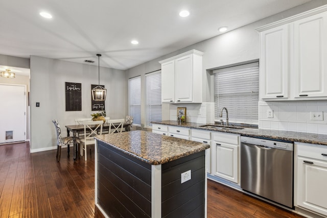 kitchen featuring dishwasher, sink, white cabinetry, and dark stone counters