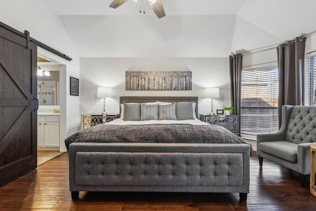 bedroom with dark hardwood / wood-style flooring, vaulted ceiling, ceiling fan, ensuite bathroom, and a barn door