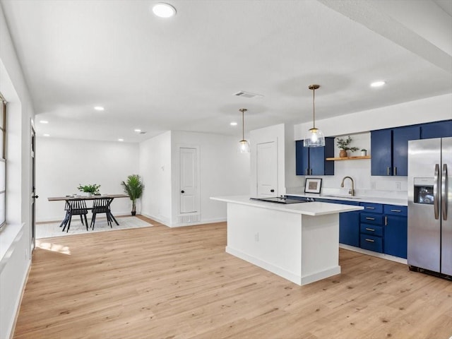 kitchen featuring a kitchen island, black stovetop, stainless steel fridge with ice dispenser, blue cabinetry, and light wood-type flooring