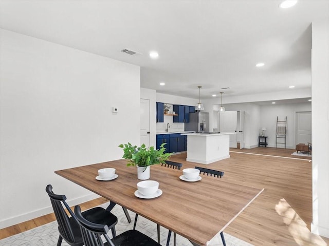 dining area featuring sink and light hardwood / wood-style flooring